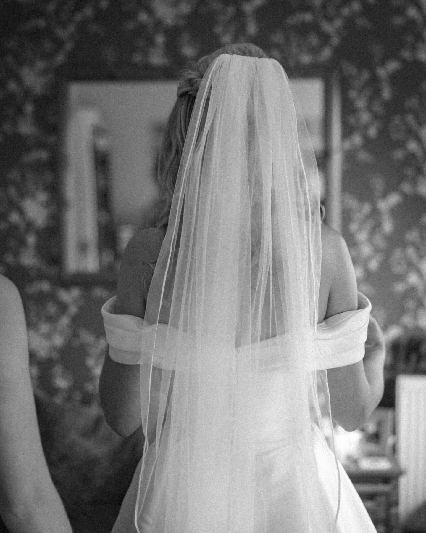 Bride under a flowing veil in soft natural light